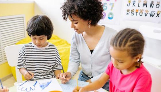 Children painting with an early childcare worker