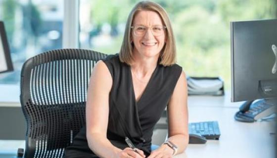 Kerry Leaver smiling at her desk 