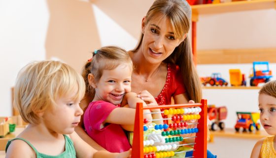 Childcare educator playing with two children