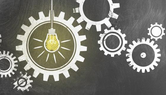 Cogs in a machine with a lightbulb in the middle
