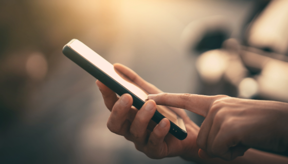 An image showing a hand holding a smart phone