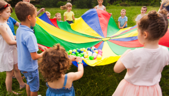 An image showing children holding a colourful parachute