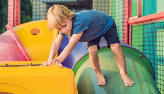 Preschool boy playing on colourful play equipment