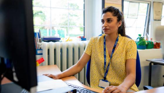 Educator Using Computer To Update Policy