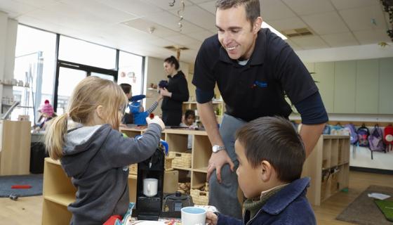 Male teacher interacting with preschool children