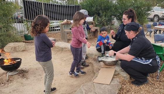 Children and educators from Wandana Ave Early Learning and Kinder mix up damper in their outdoor play space