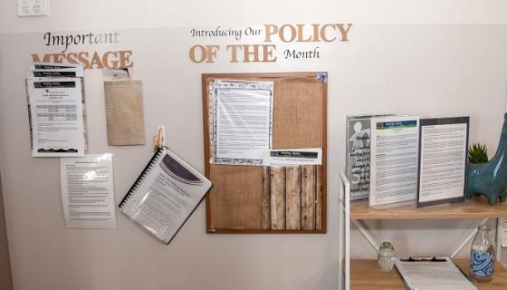 Pin board at education and care service with &#039;Introducing the policy of the month&#039; on it