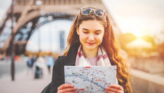 Female student with map near Eiffel Tower